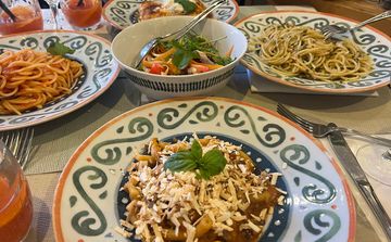 Table avec des plats de pates dans un restaurant à Taormina